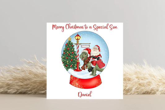 Santa riding a Dinosaur in a Snow Globe Christmas Card- Personalise with name and Relationship