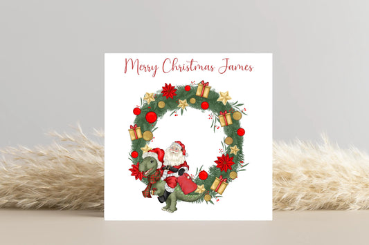 Santa riding a Dinosaur in a Wreath Christmas Card- Personalised